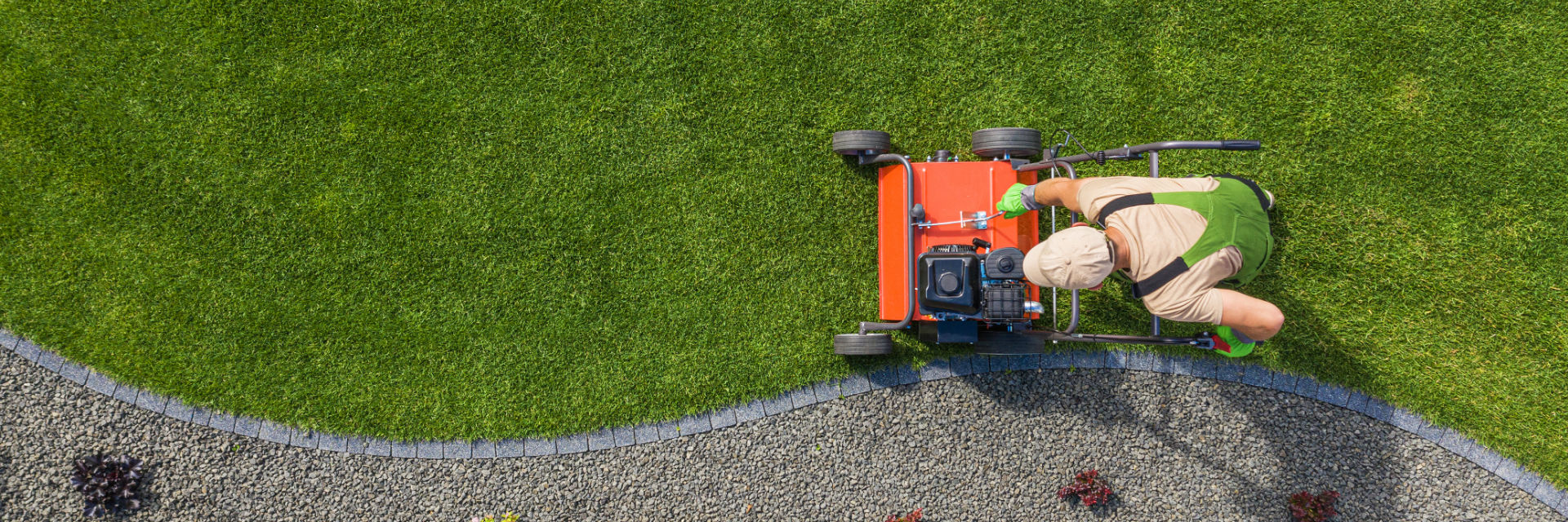A professional landscaper mowing a lawn.