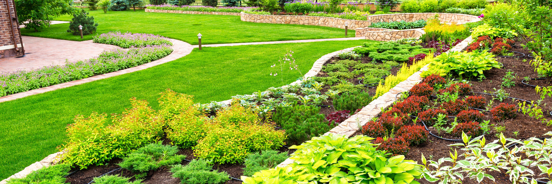 Professionally landscaped and maintained garden with hardscapes and a manicured lawn.