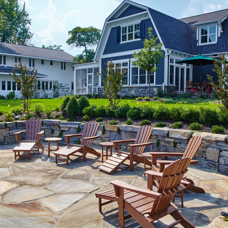 Suburban Backyard Patio with Adirondack Chairs and Lush Garden
